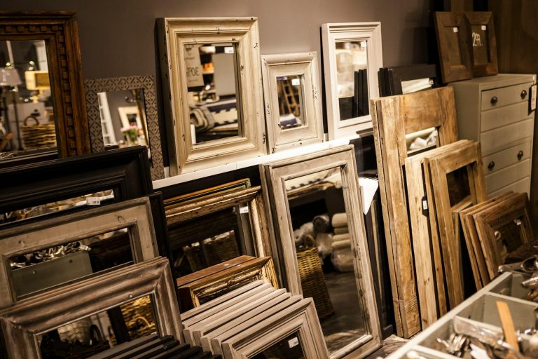 A collection of vintage-style mirror frames on display in a cozy interior shop setup.